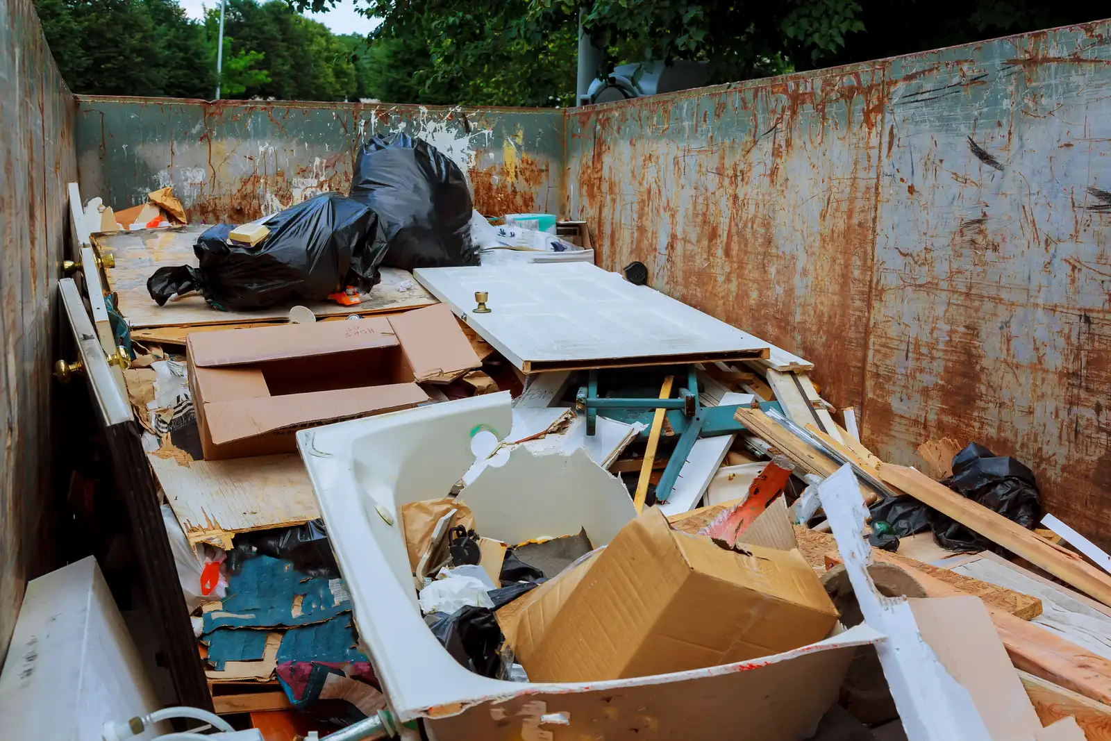 Voller Sperrmüll-Container mit unsortiertem Hausrat – Entrümpeln in Eigenregie mit gemietetem Container